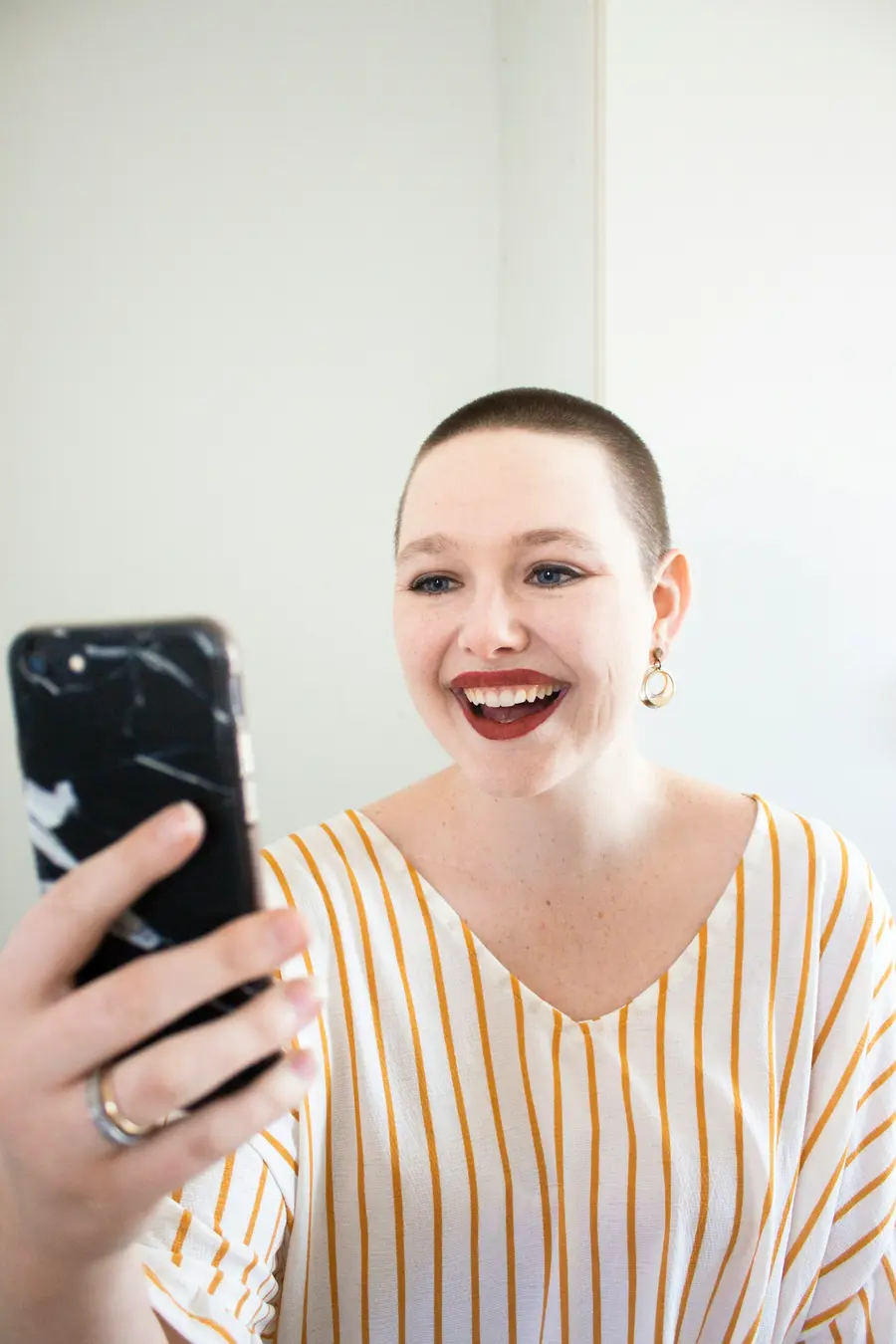 Mulher sorrindo com o celular na mão