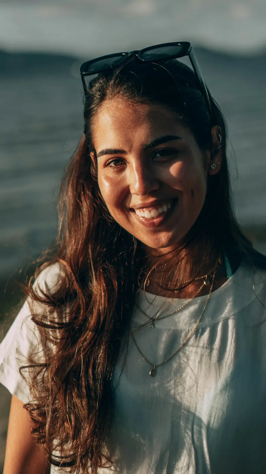 Mulher nordestina sorridente ao ar livre com céu azul e luz do sol