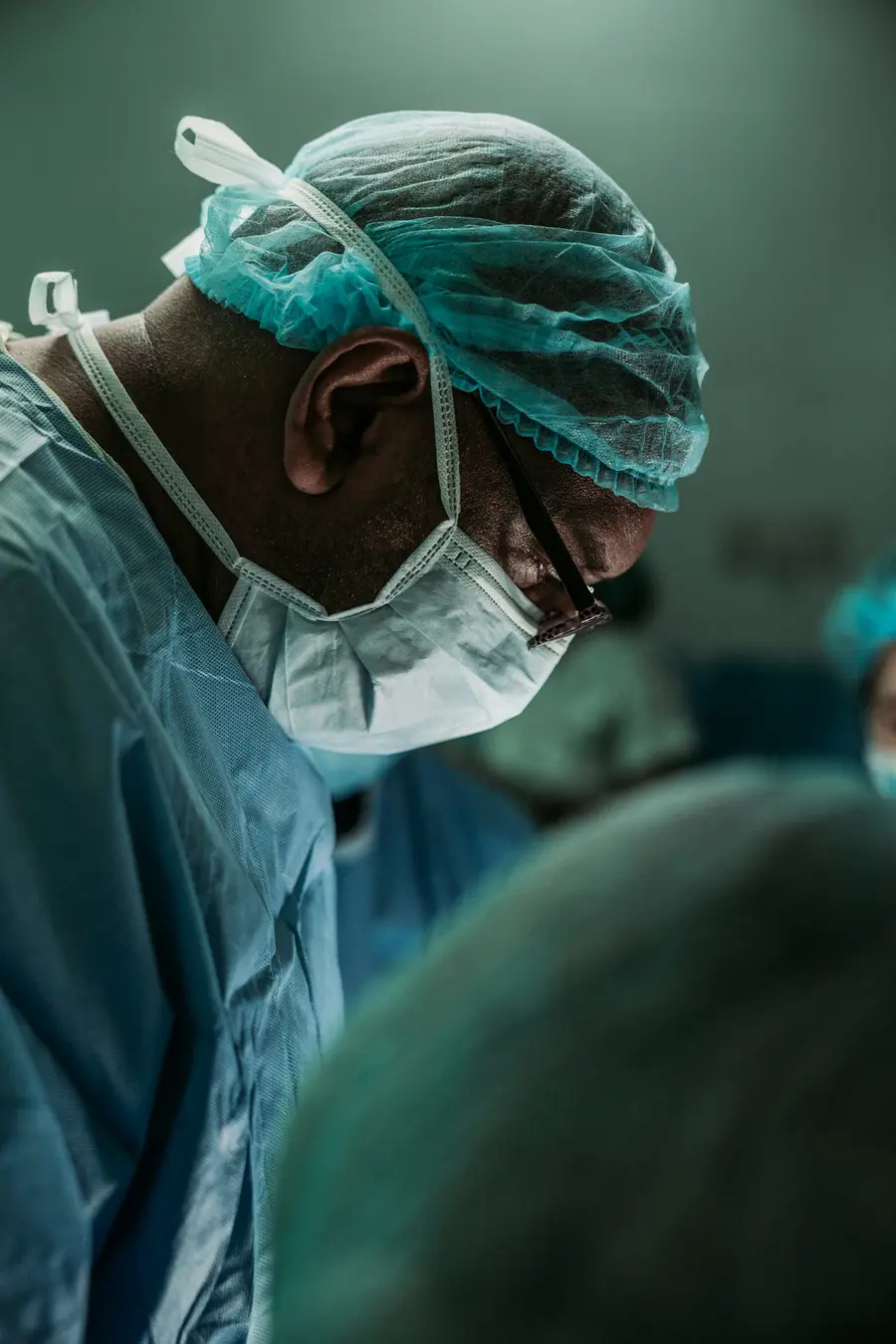 Cirurgiã ou cirurgião sorridente de jaleco branco num corredor de hospital claro e moderno e detalhes em azul