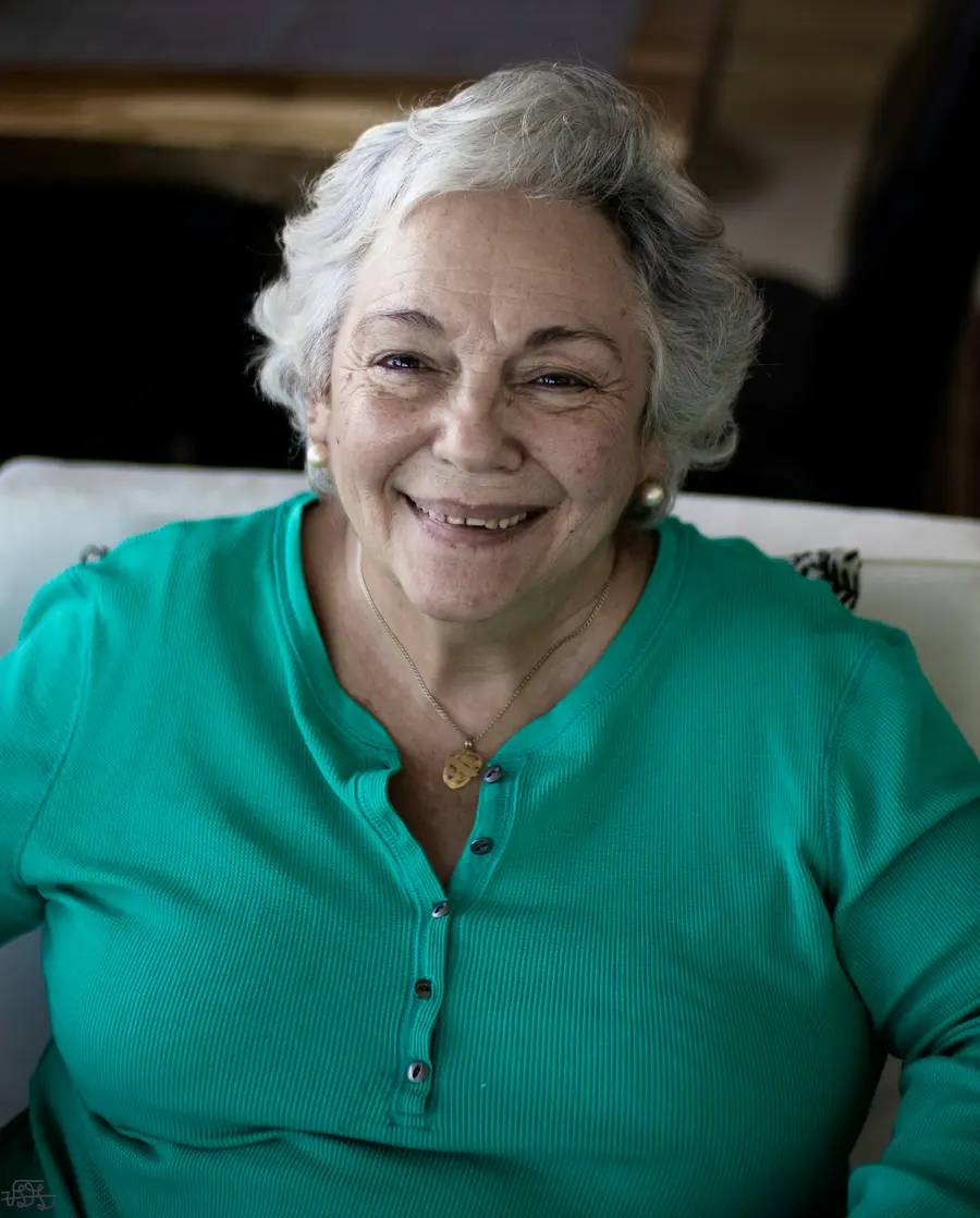 Senhora sorrindo de blusa verde