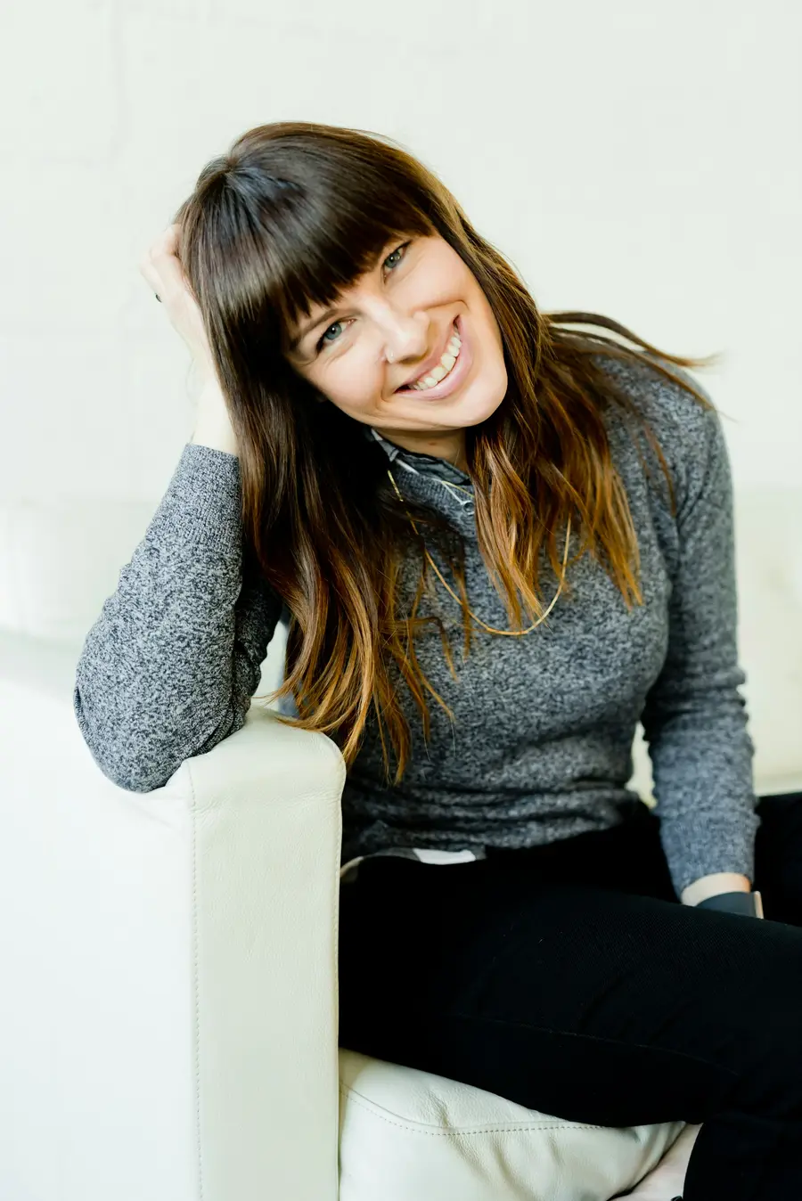 Mulher sorrindo sentada no sofá