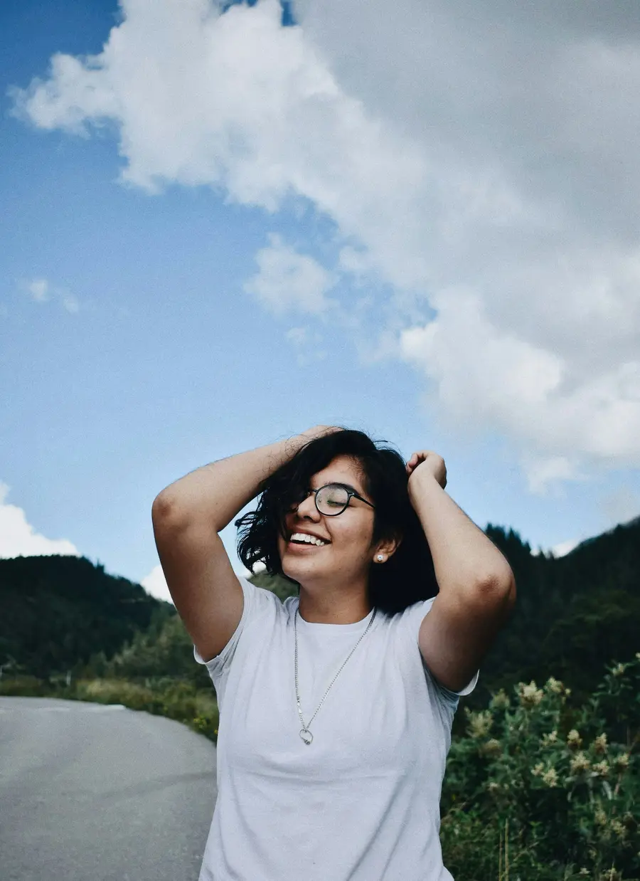 Jovem sorrindo sob céu azul