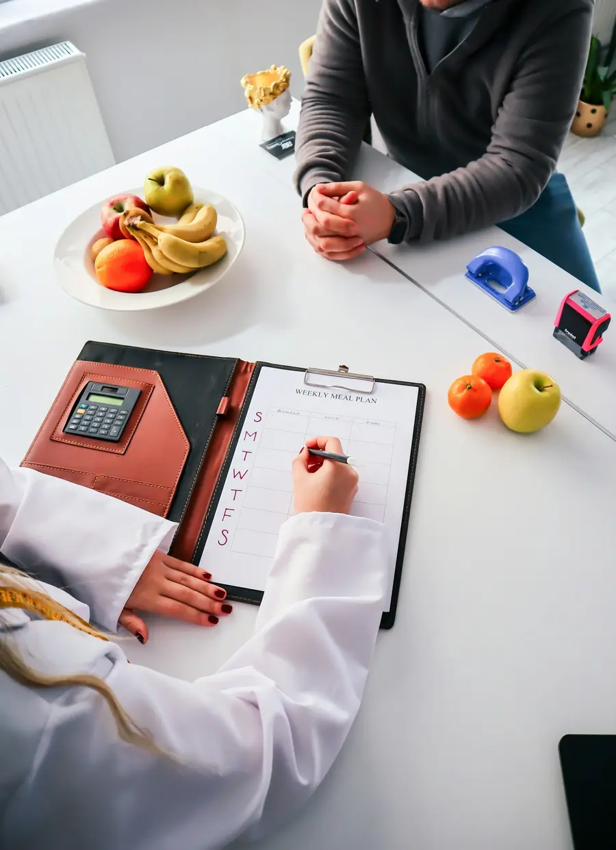 Prancheta e frutas sobre a mesa durante uma consulta de nutrição