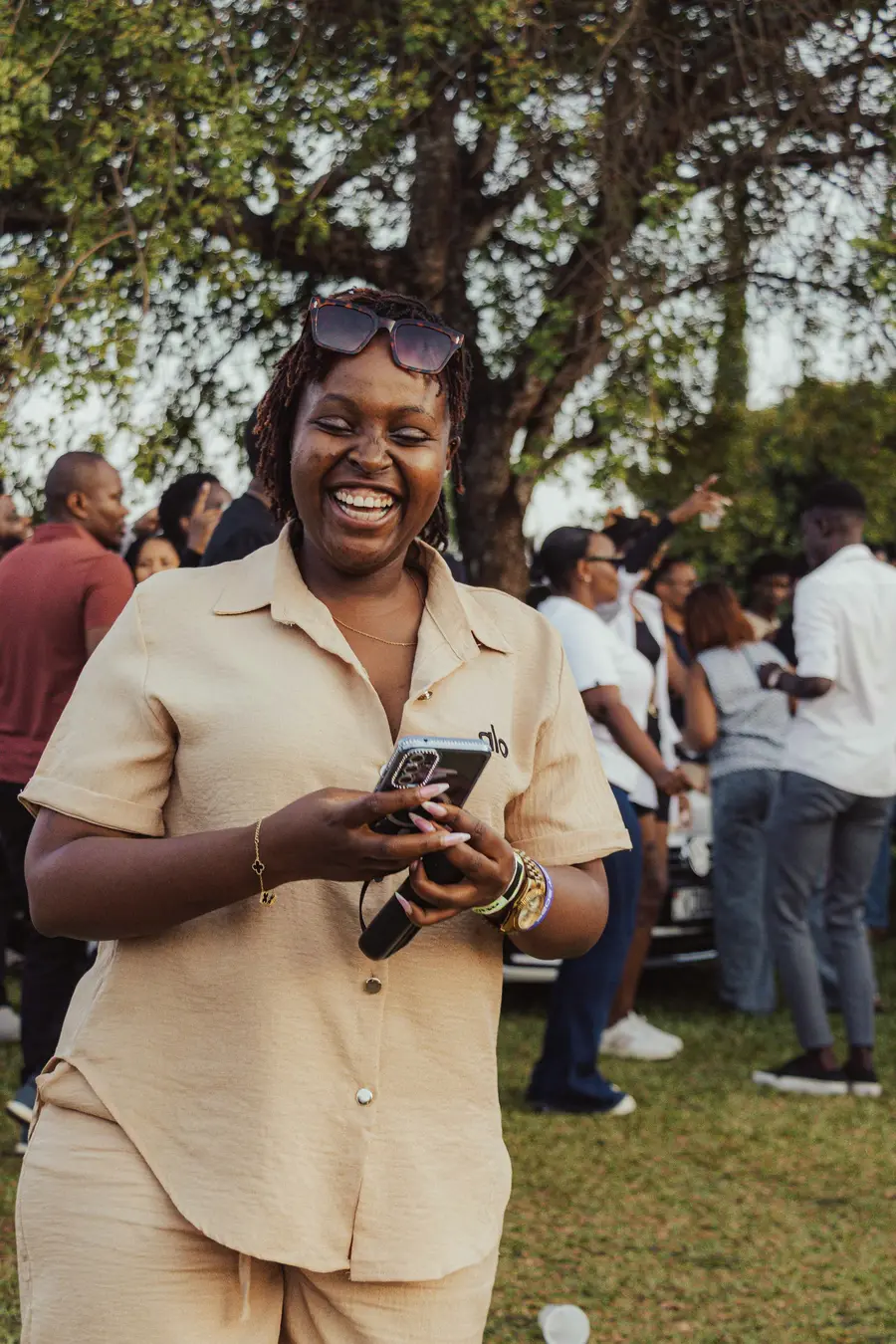 Mulher sorridente usando o celular ao ar livre no Rio de Janeiro, com céu azul e