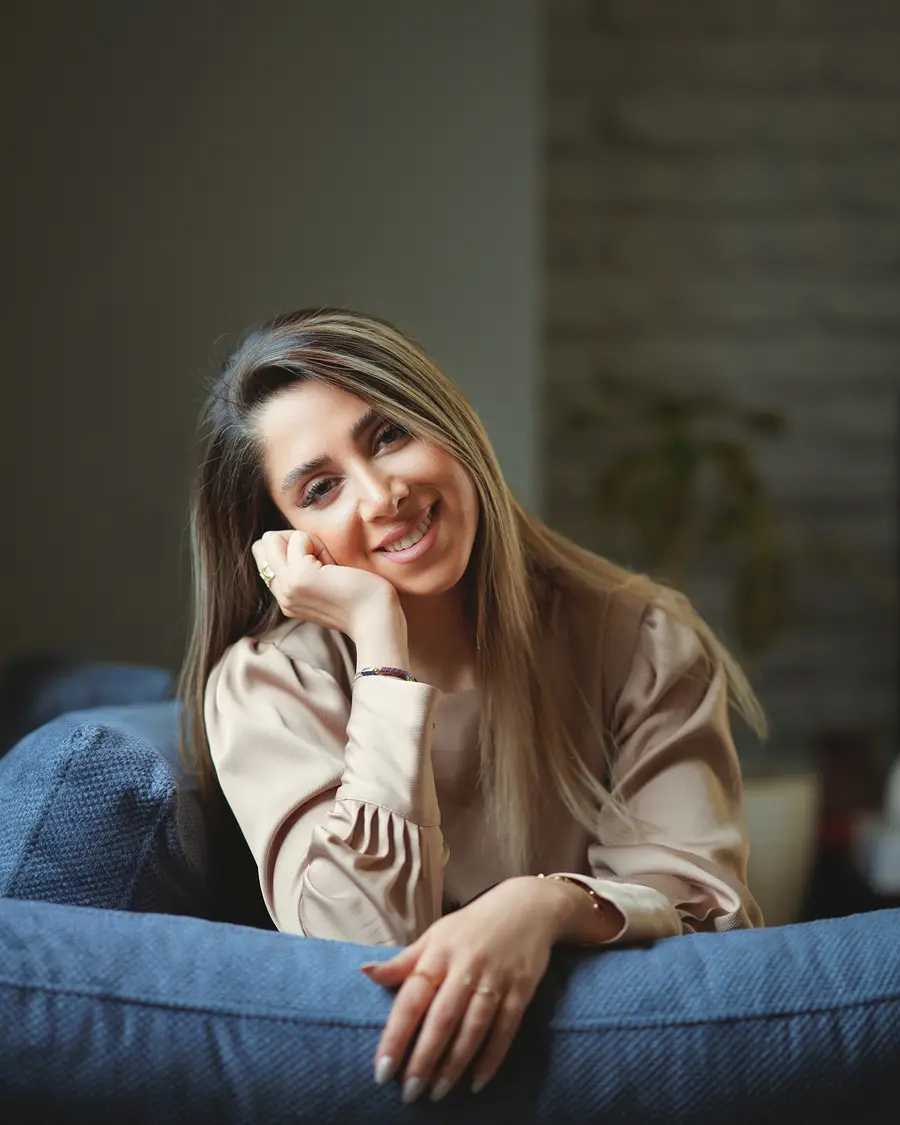 Mulher sorrindo sentada no sofá