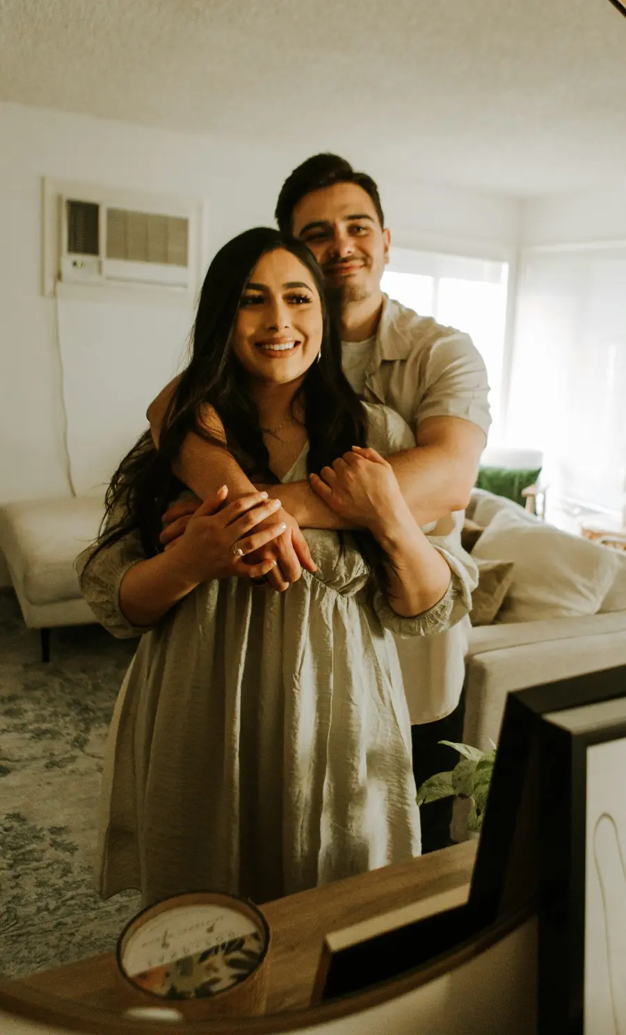 Casal sorridente no sofá de casa