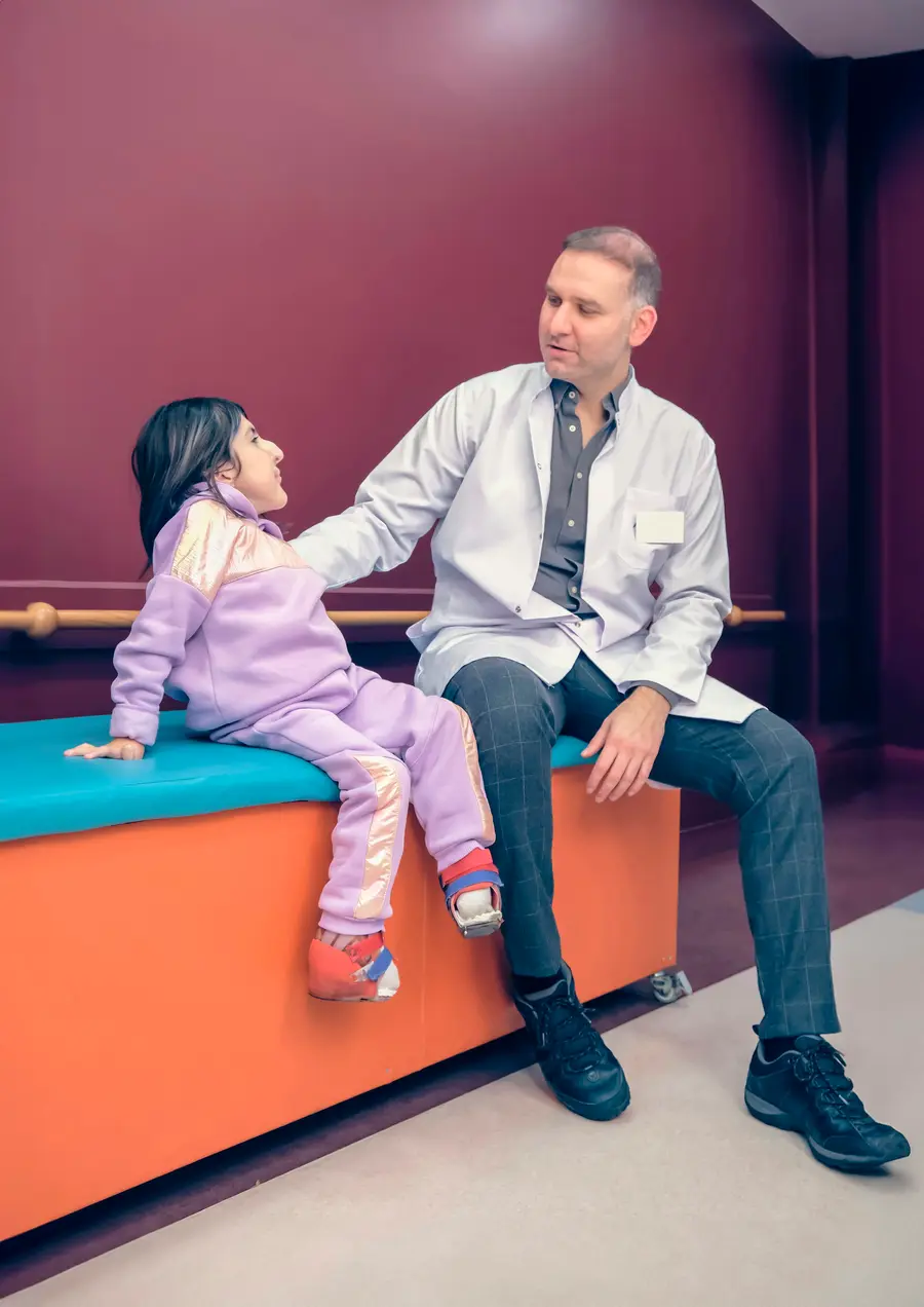 Pediatra examina uma menina no consultório
