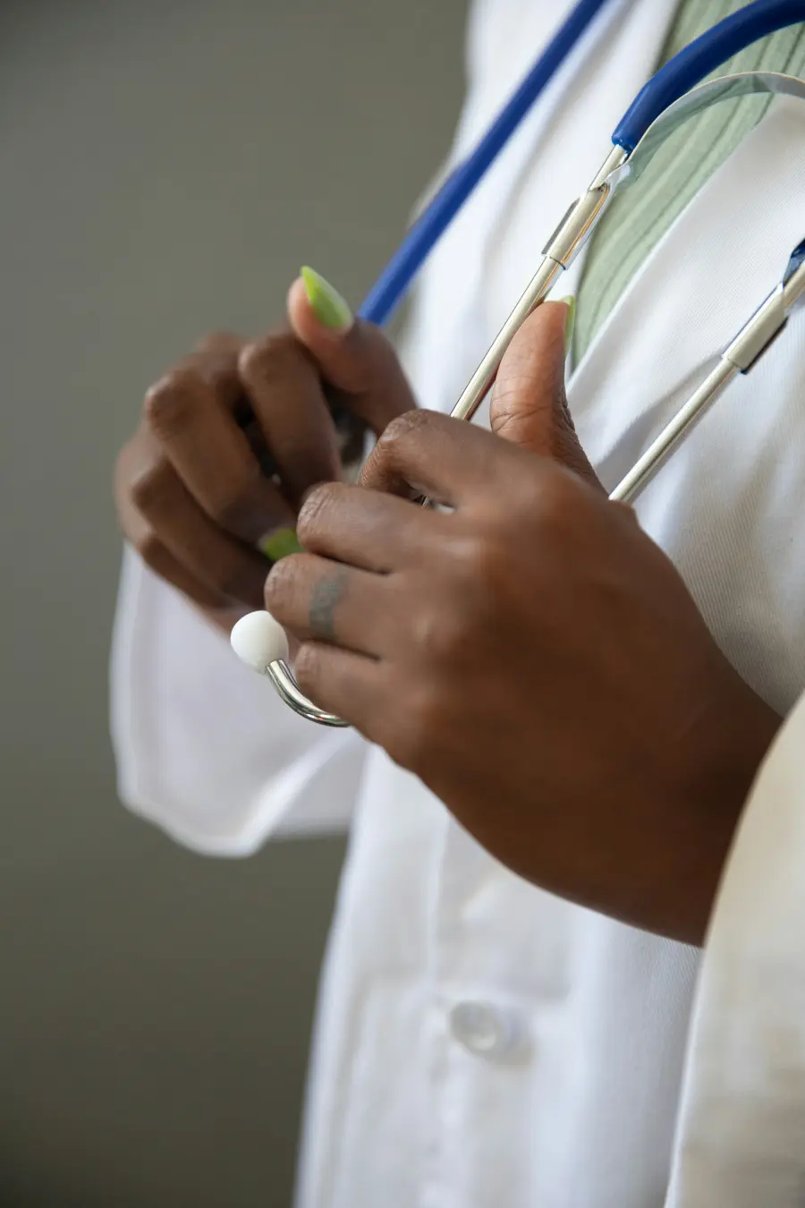 Médico sorridente conversando com paciente adulta em consultório moderno e claro, janela e detalhes azuis