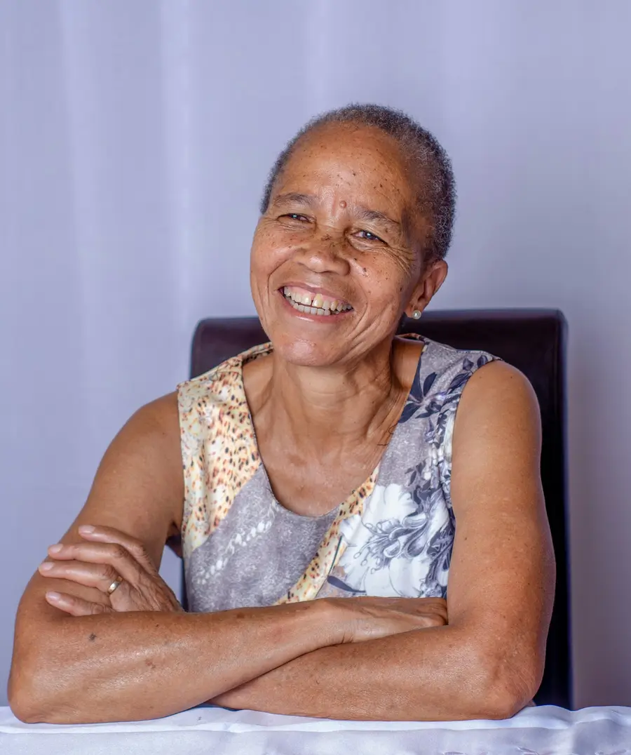 Enfermeira sorrindo atendendo senhor de uns 70 anos em clínica clara e moderna