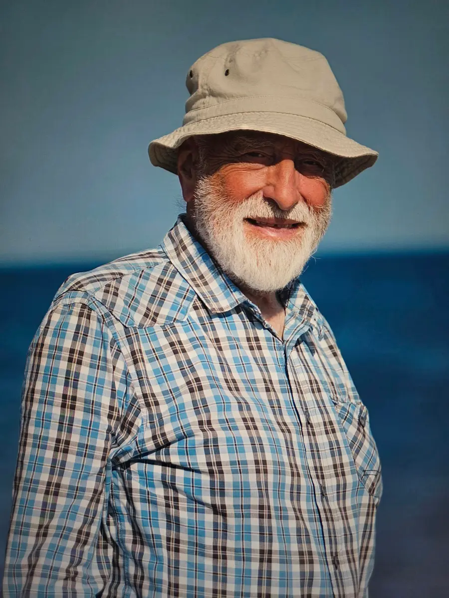 Senhor de barba branca e chapéu sorrindo