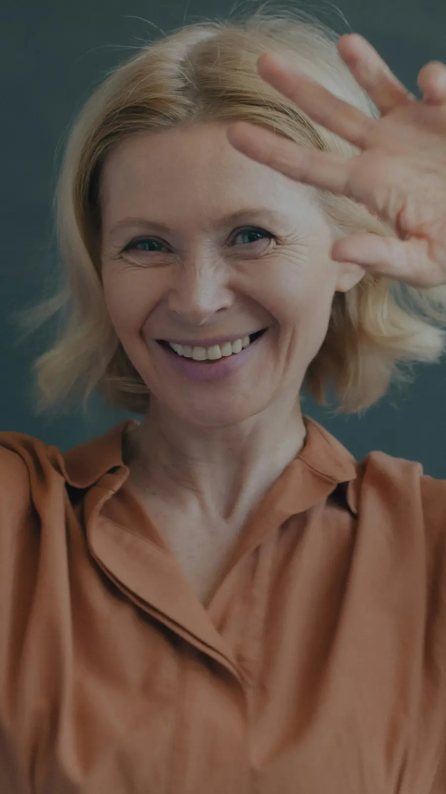 Mulher sorrindo e acenando