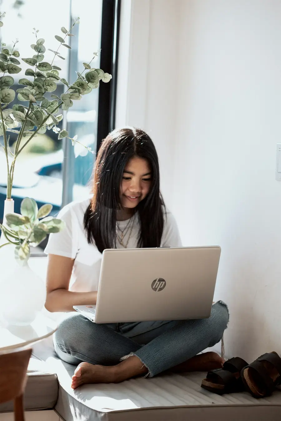 Mulher usando o notebook sentada no chão da sala
