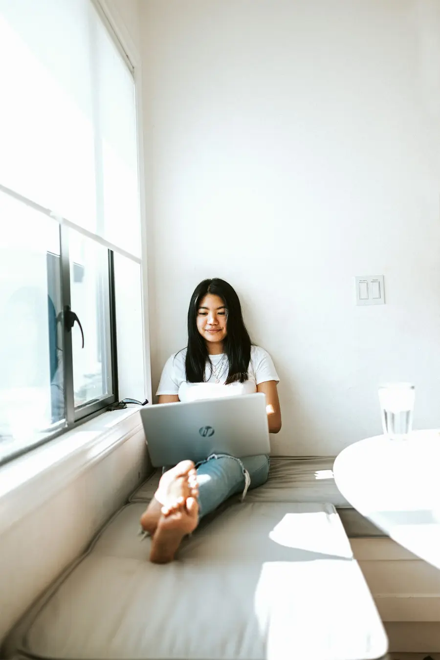 Mulher usando o notebook numa sala iluminada