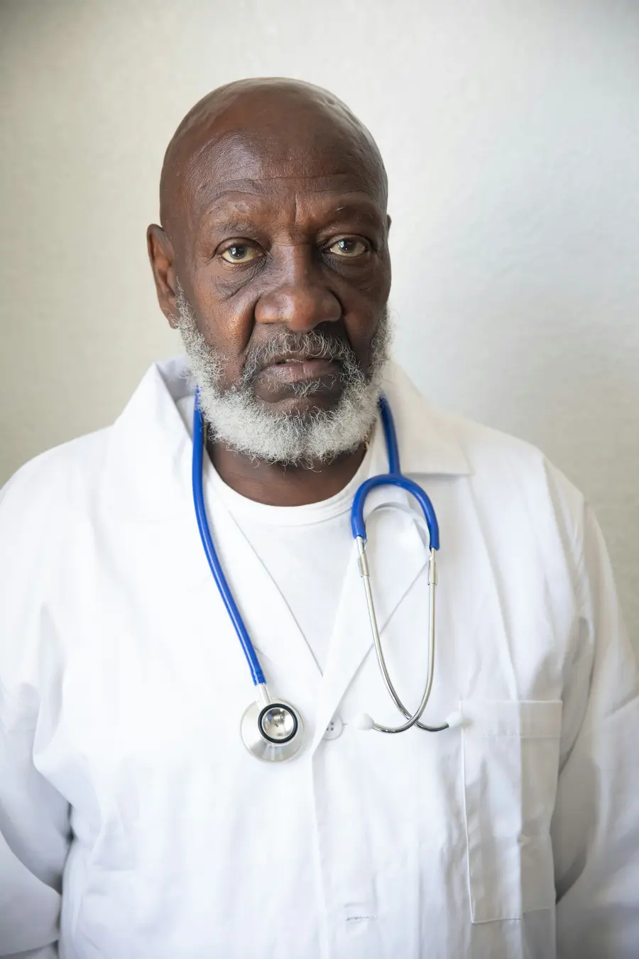 Médico experiente sorri no consultório
