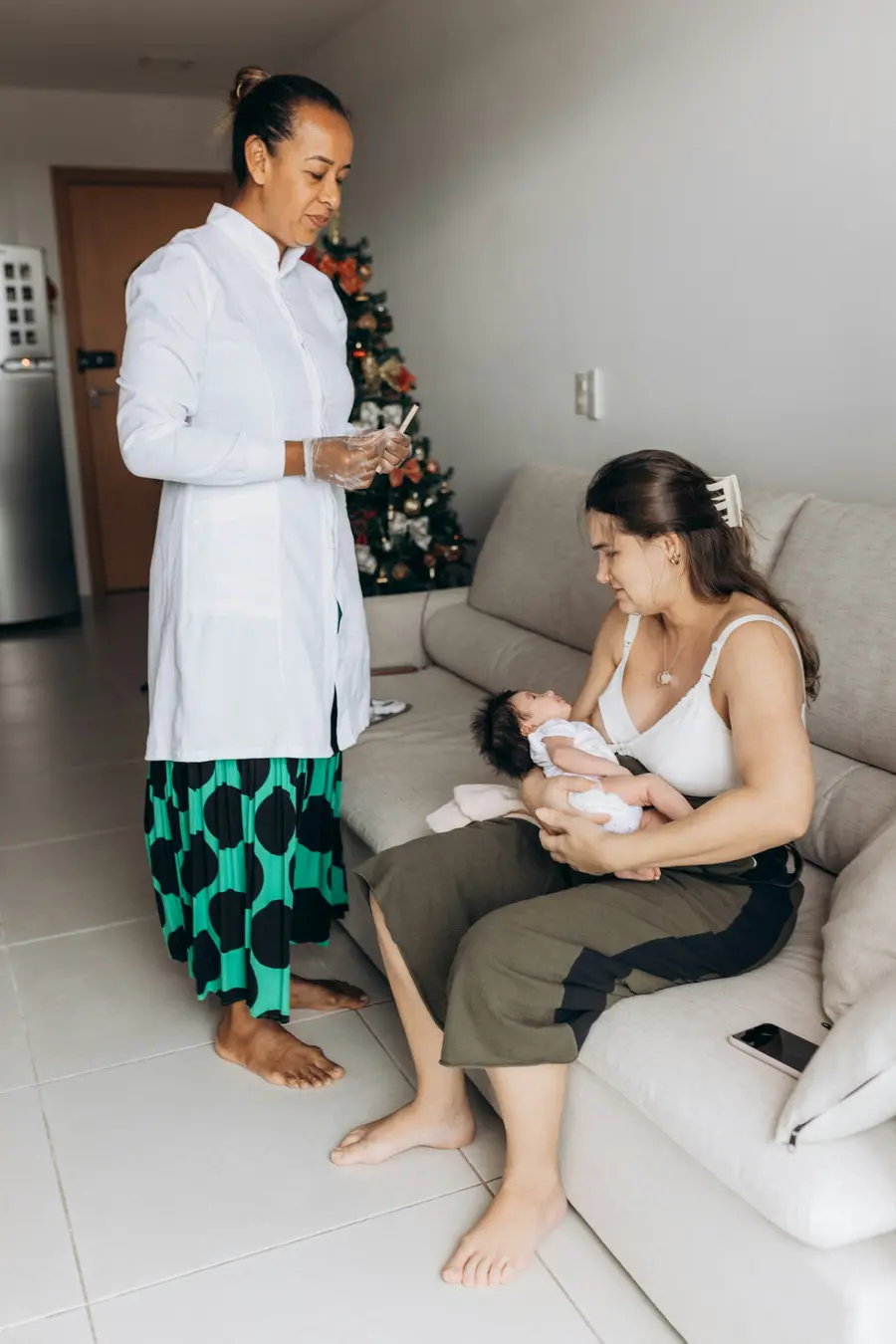 Médico atende mãe com bebê no colo