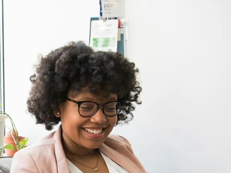 Mulher sorri ao conferir valores no celular