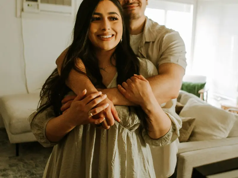 Casal sorridente no sofá de casa