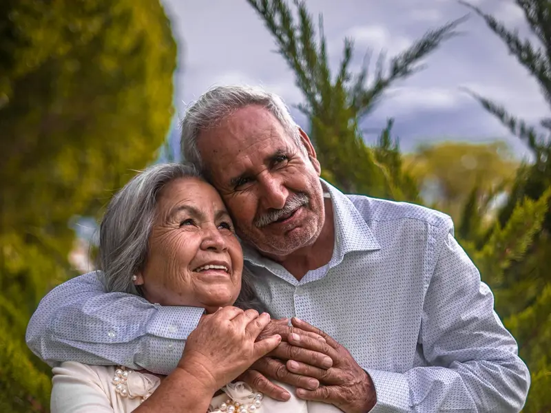 Casal de idosos abraçado ao ar livre