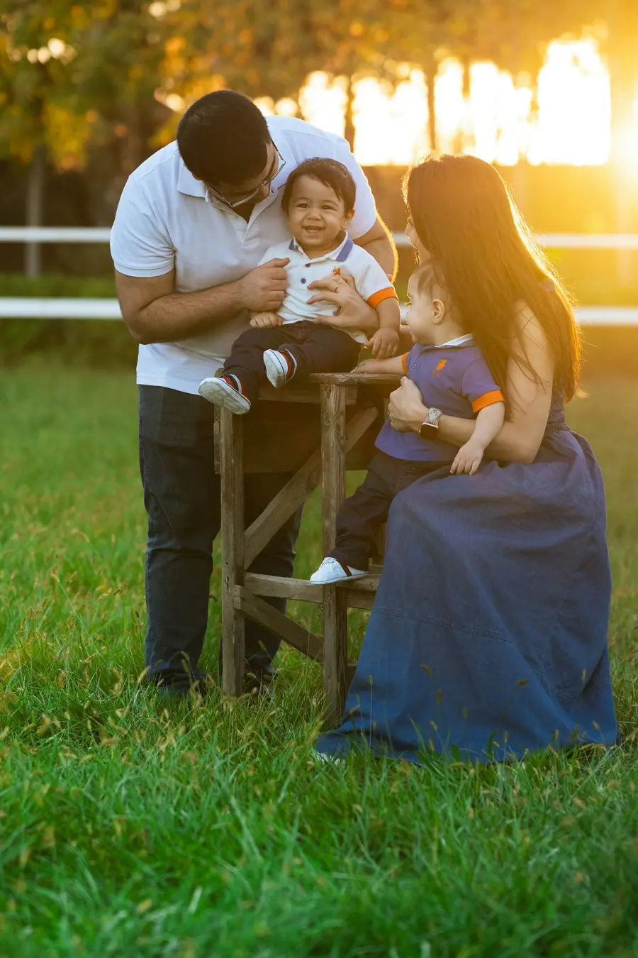 Mãe sorrindo com o filho pequeno no colo em casa clara, tons de azul e branco