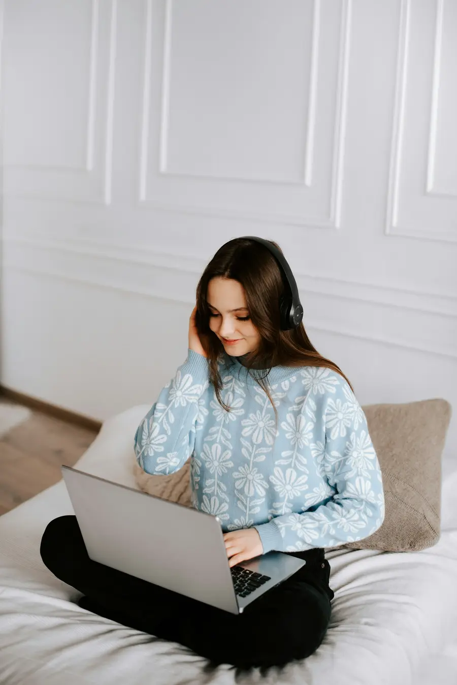 Mulher usando o notebook sentada na cama