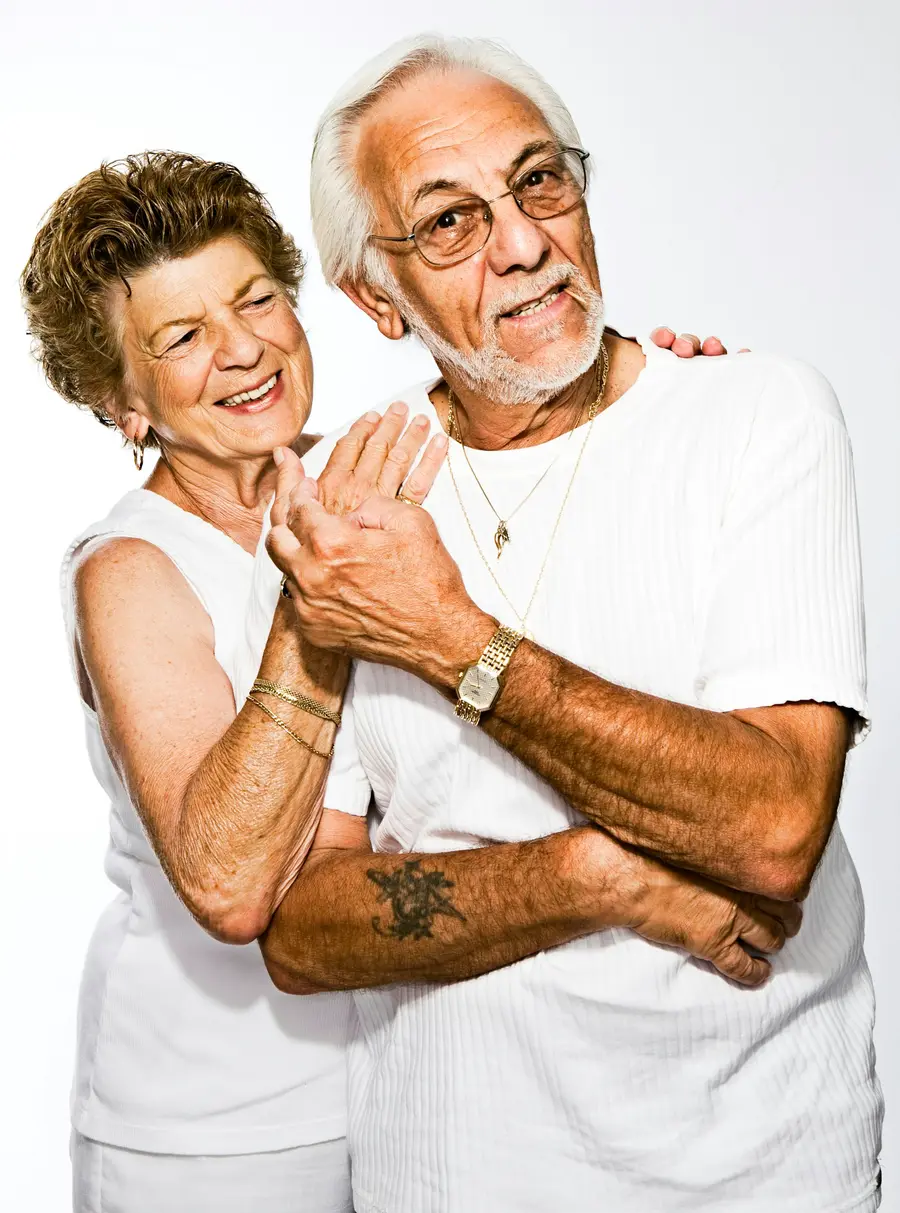 Casal de idosos sorrindo abraçado