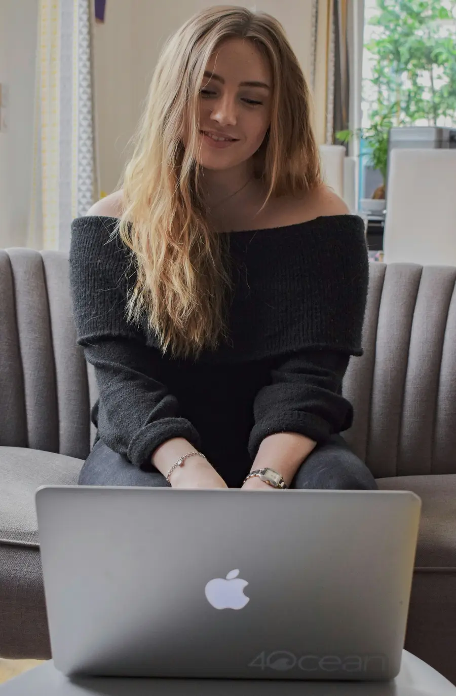 Mulher sorrindo com o notebook no colo