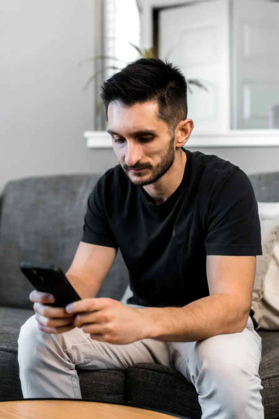 Homem usando o celular no sofá
