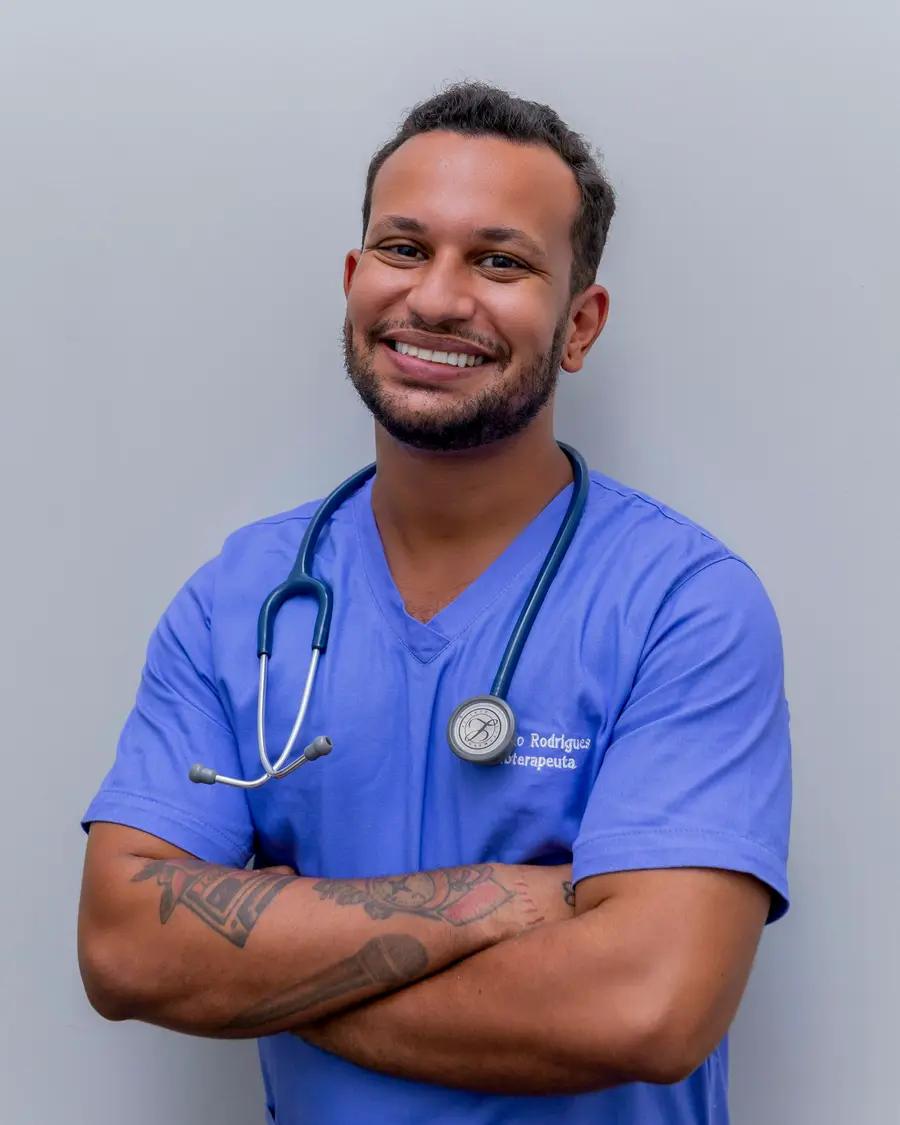Médico sorridente conversando com uma paciente jovem num consultório claro e detalhes em azul