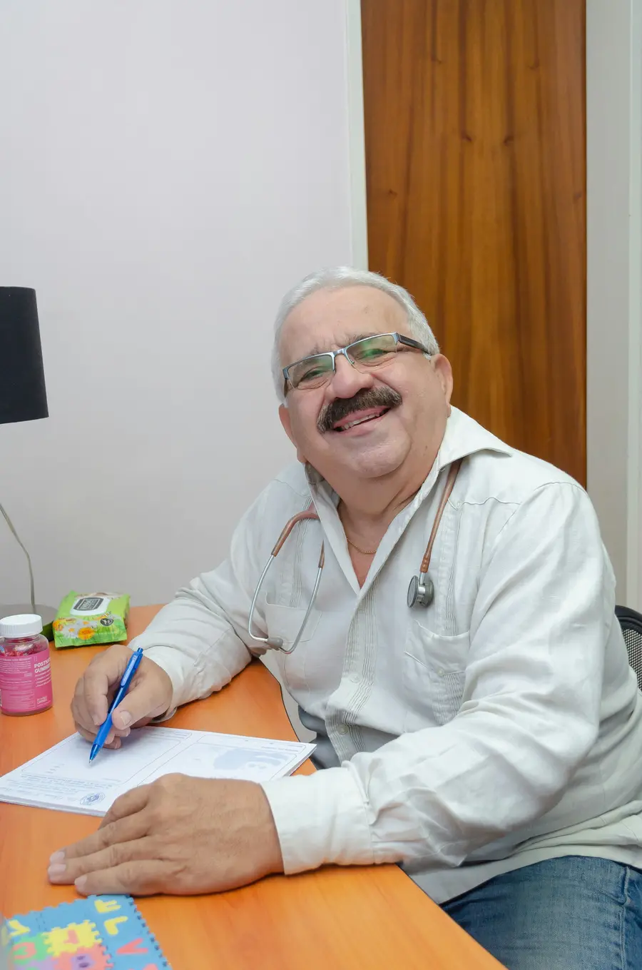 Médico sorrindo enquanto preenche um formulário