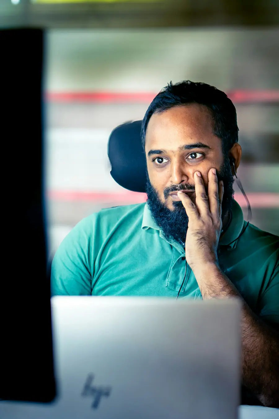 Funcionário sorrindo num ambiente de trabalho claro, com crachá e camisa azul
