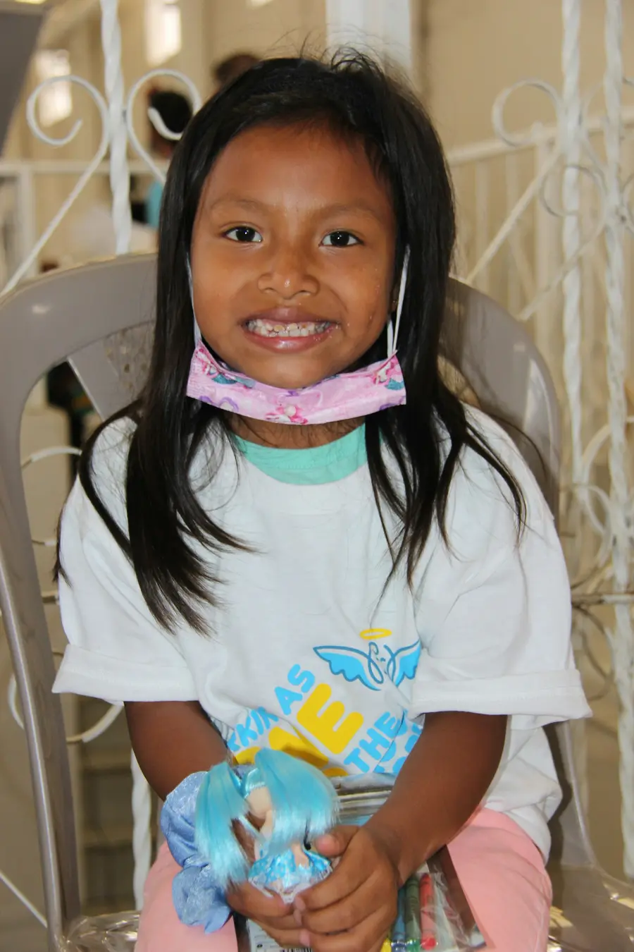 Menina sorrindo na cadeira do dentista, com a dentista ao lado e colorido, tons de azul