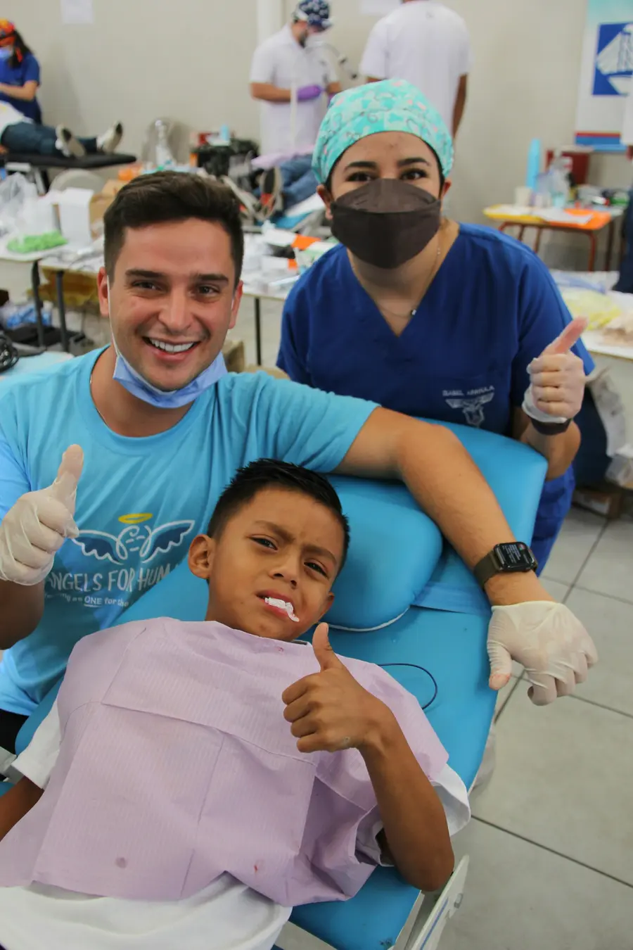 Dentista e auxiliar sorrindo com um menino