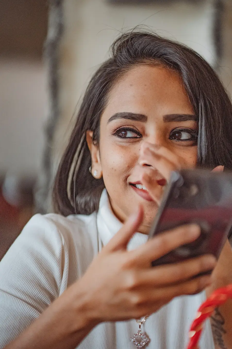 Mulher sorridente segurando o celular em, tons de azul