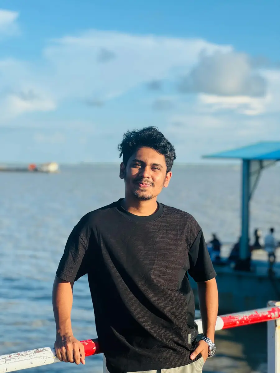 Rapaz sorrindo com o mar ao fundo
