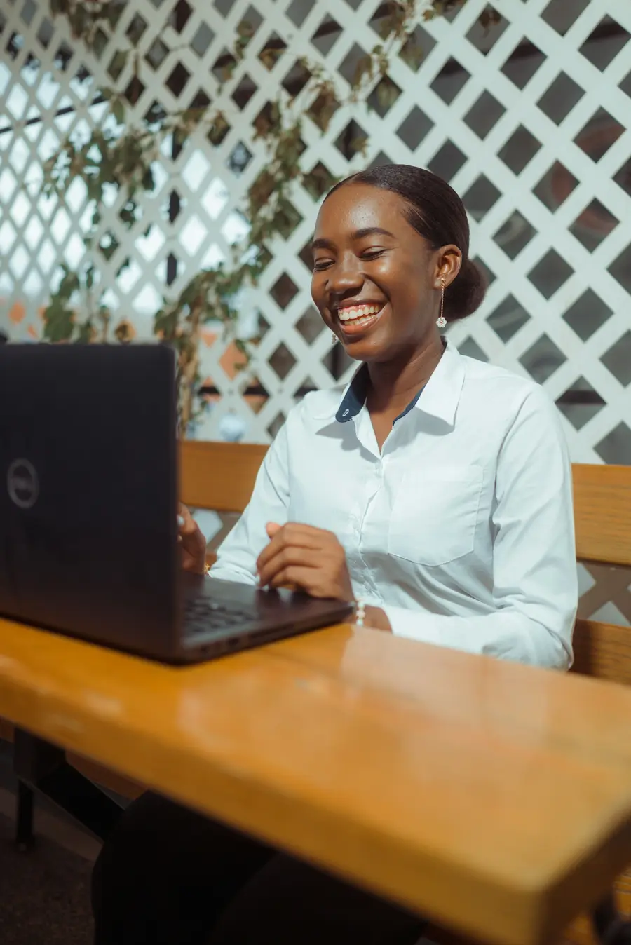 Jovem profissional sorridente com notebook em escritório claro, tons de azul