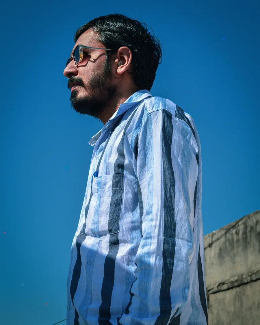 Homem de camisa xadrez azul sob céu azul