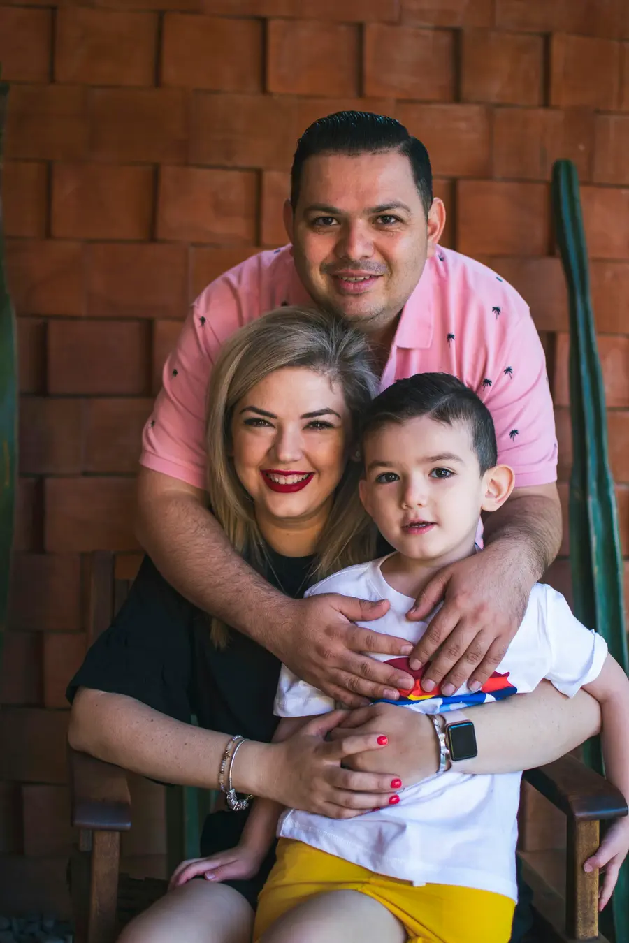 Família jovem com criança pequena sorrindo em casa clara