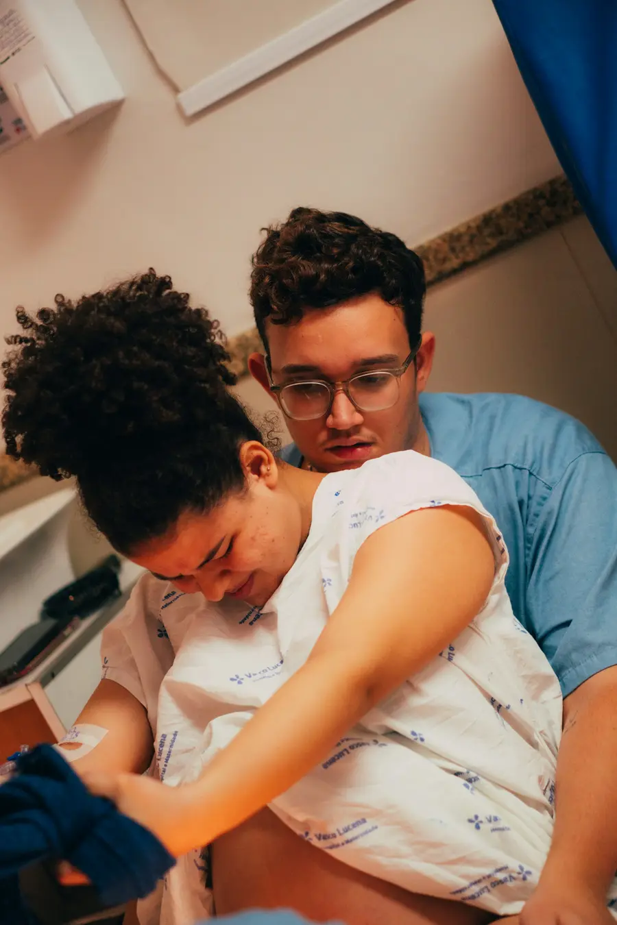 Médica sorridente conversando com uma paciente em consultório claro