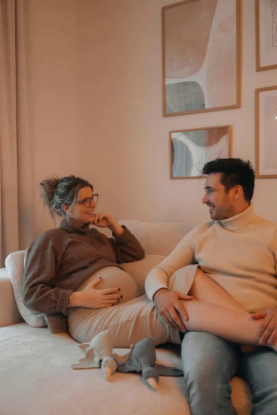 Gestante sorridente com o companheiro, em casa