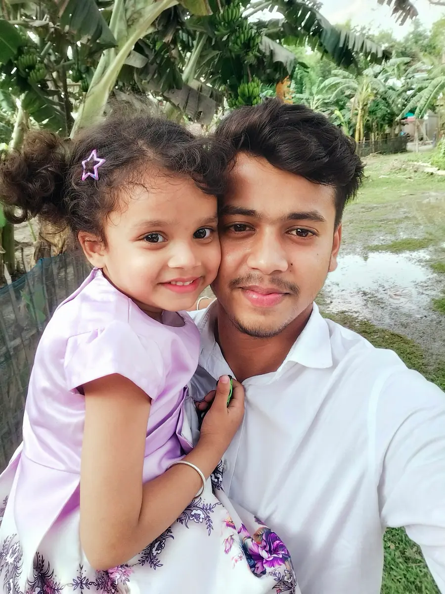 Pai e filha sorrindo ao ar livre em dia ensolarado, céu azul