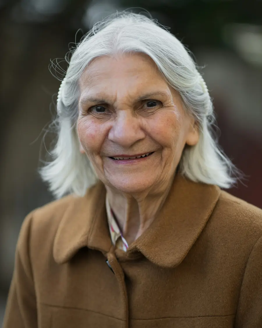 Mulher de cerca de 60 anos sorrindo em consulta com um médico, em
