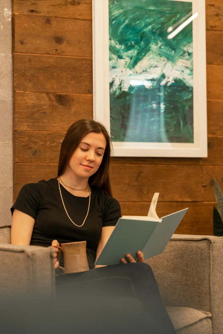 Mulher sorridente lendo documentos à mesa em