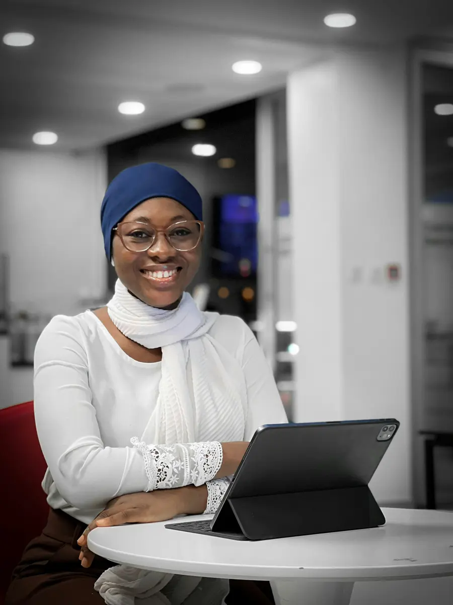 Médica sorrindo diante do tablet no consultório