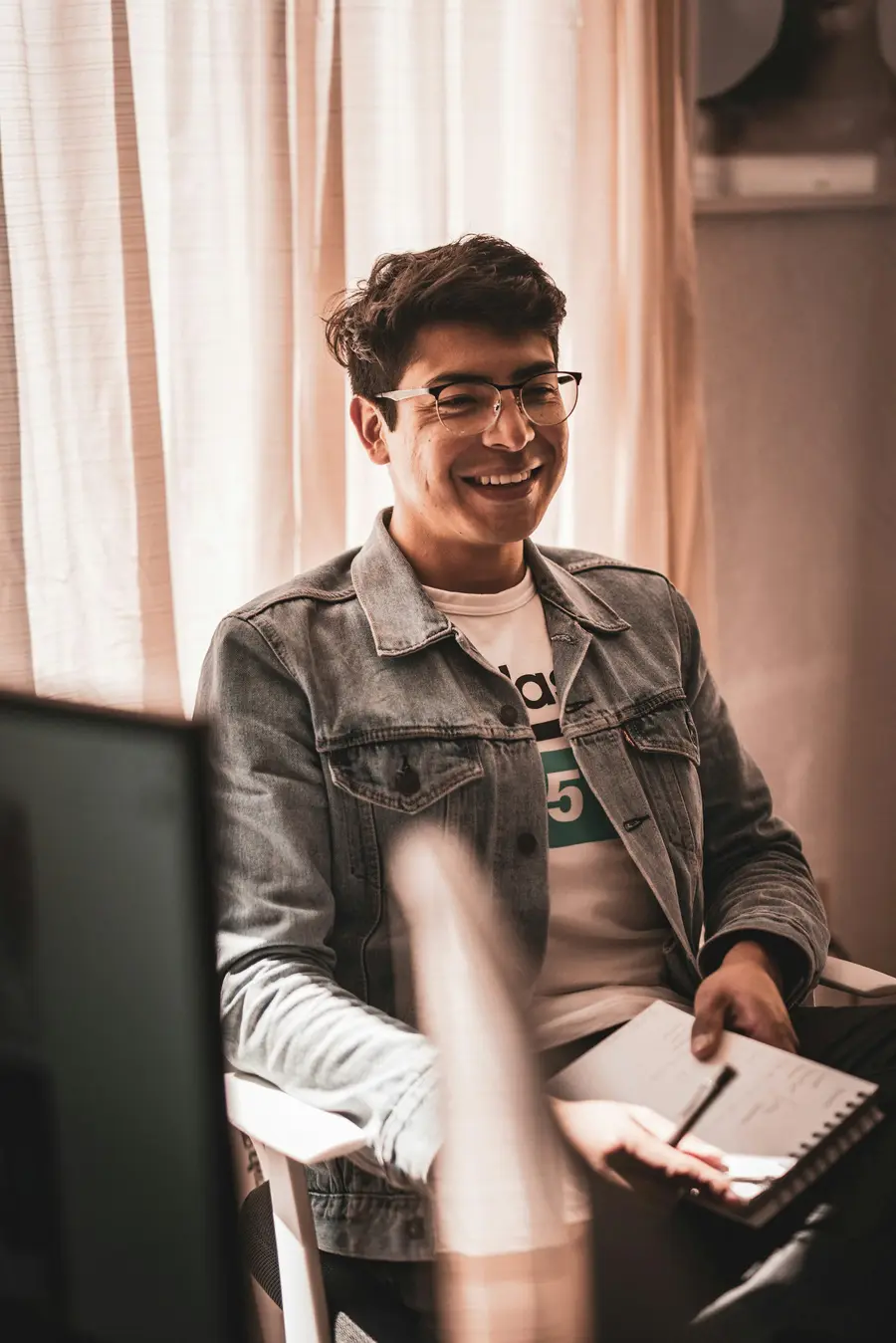 Homem sorrindo sentado numa poltrona