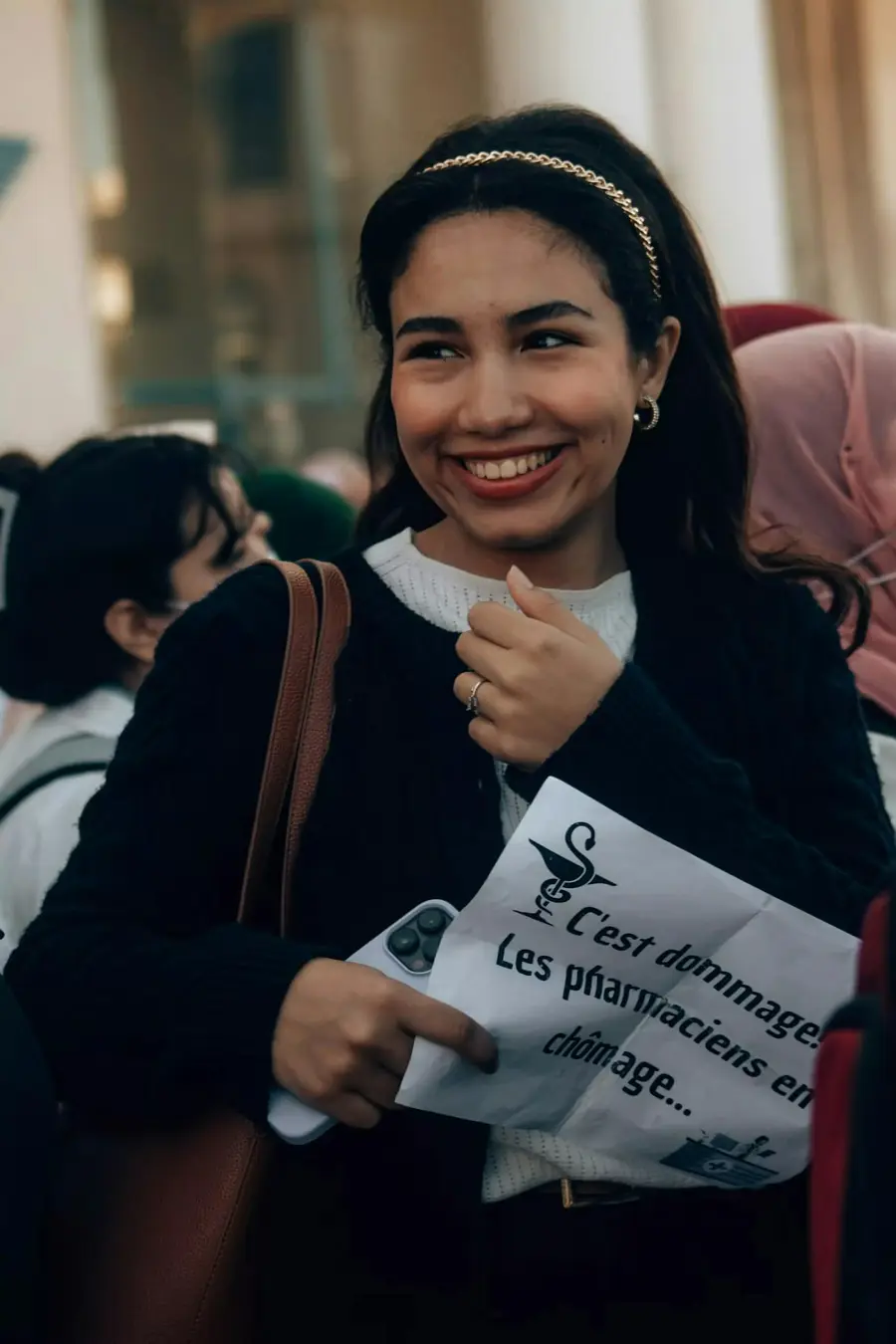 Mulher jovem sorridente analisando um documento impresso num escritório claro