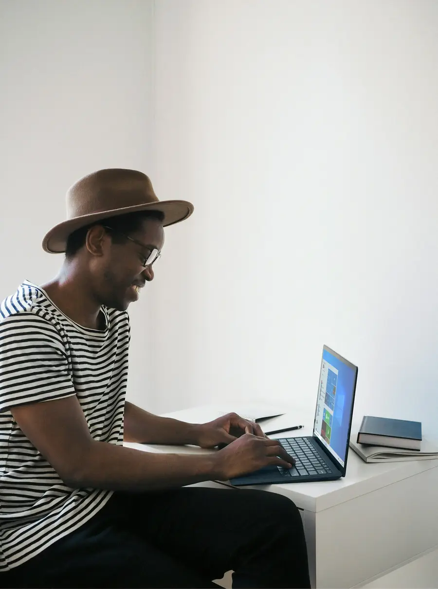 Homem de chapéu usando o notebook
