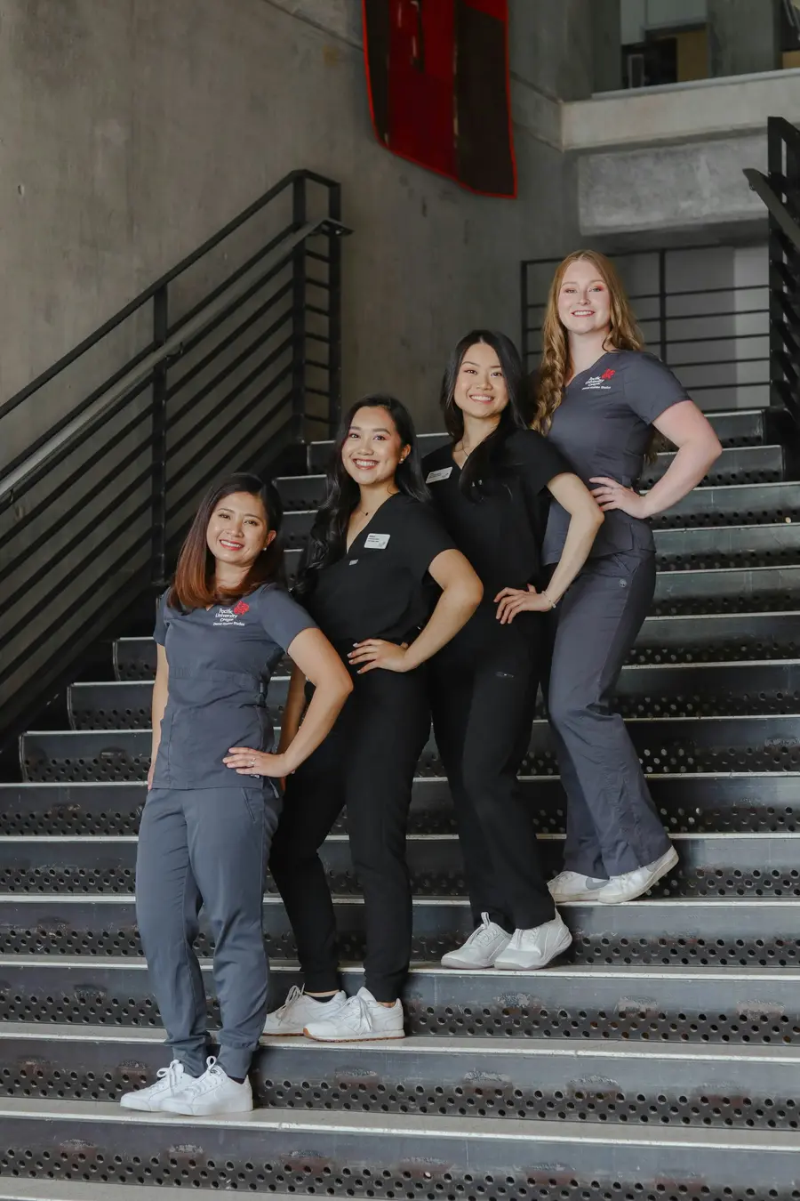 Equipe de profissionais de saúde sorrindo na escada de um hospital
