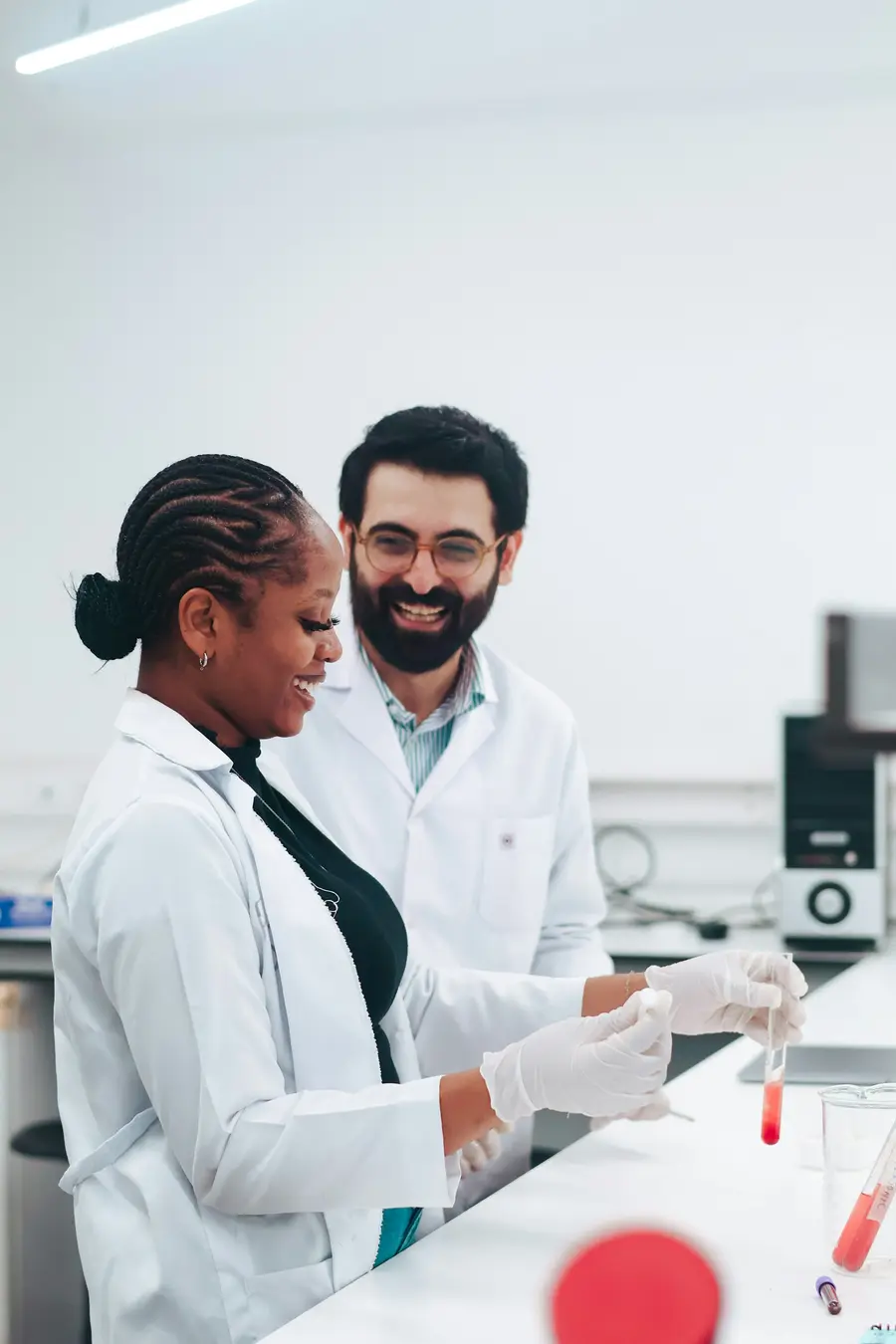 Médica e médico analisando um exame no laboratório