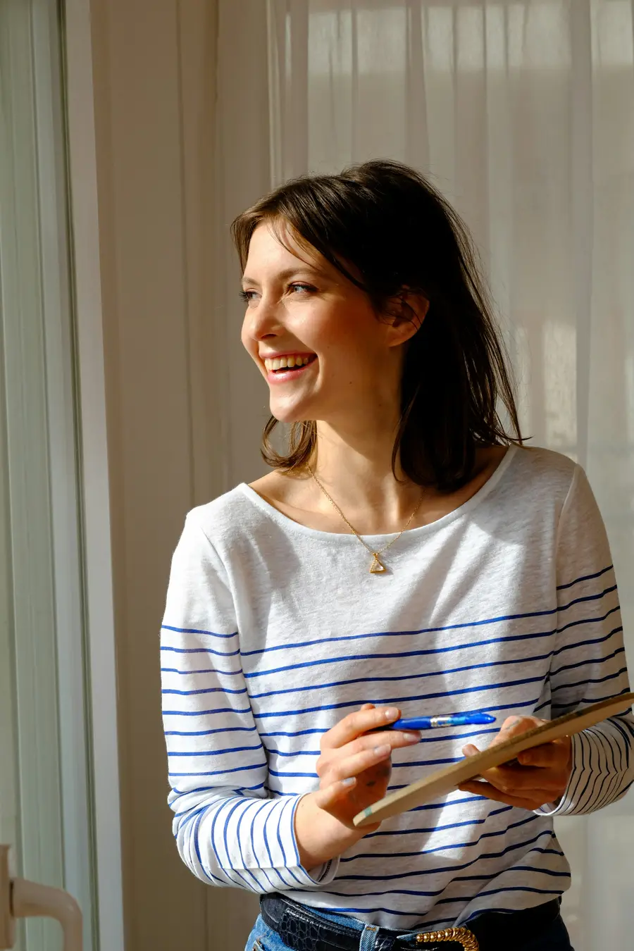Mulher sorrindo de camisa listrada