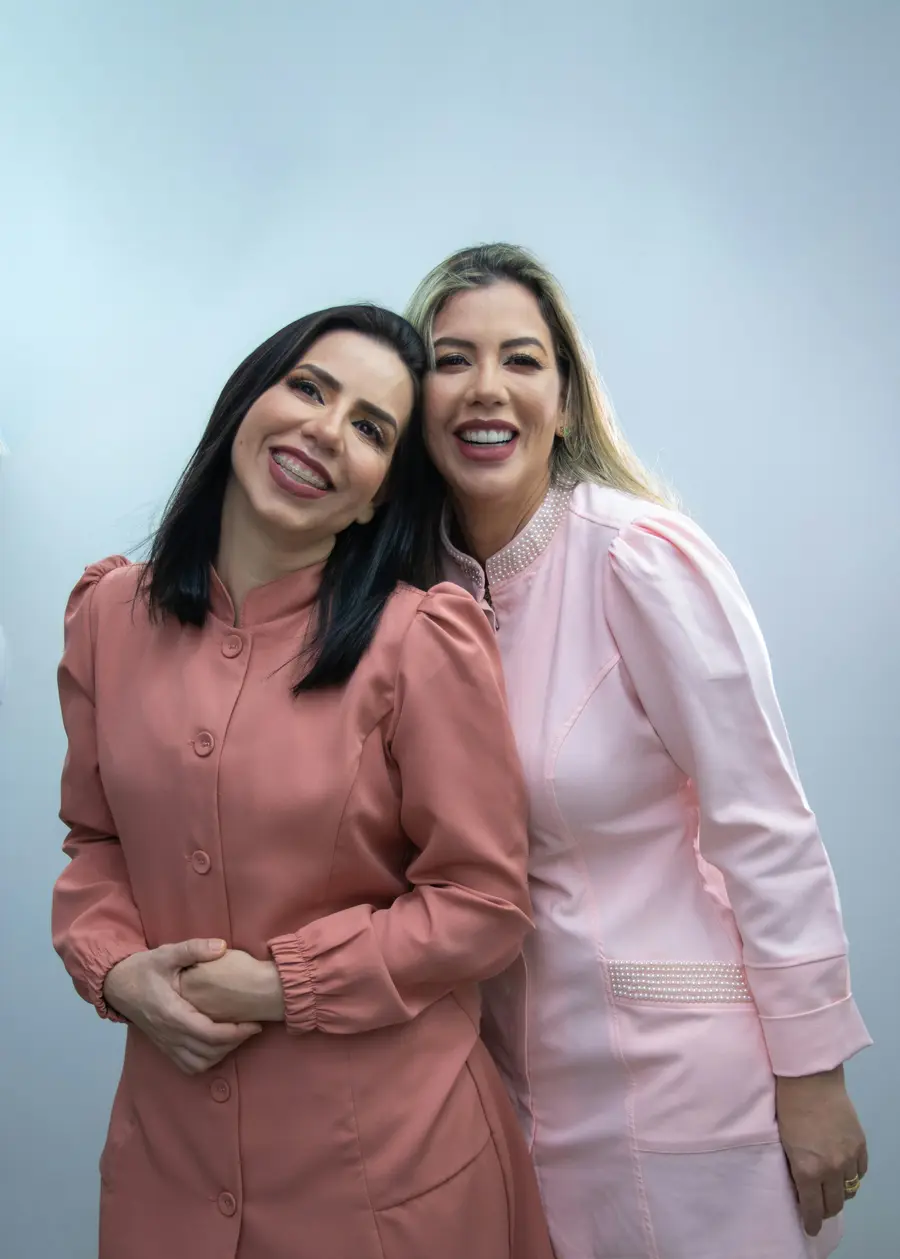 Duas médicas sorrindo lado a lado